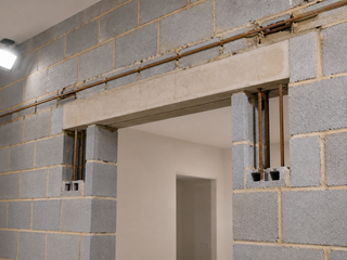 Structural lintel and rebar detail above a doorway in a load-bearing block wall, DM-spec