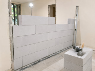 AAC internal partition wall under construction inside a villa with spirit level checking plumb