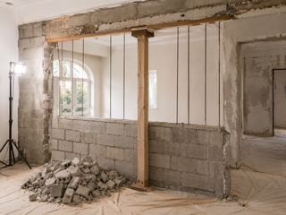Controlled internal wall removal with sawcut and temporary lintel prop in a villa